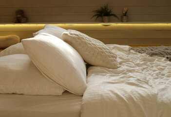 Fototapeta na wymiar bed in the bedroom, white pillows and cozy linens, close up