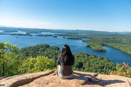 Woman enjoying the view of Squam lake from West Rattlesnake Mountain New Hampshire