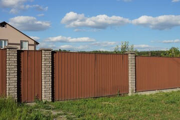 Fototapeta premium gate and part of the fence of bricks and metal in the wall on a city street