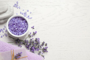 Cosmetic products and lavender flowers on white wooden background, flat lay. Space for text