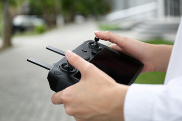 Woman with modern drone controller outdoors, closeup