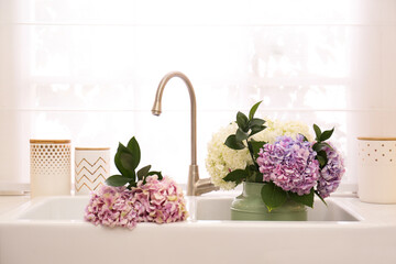 Bouquet with beautiful hydrangea flowers in sink
