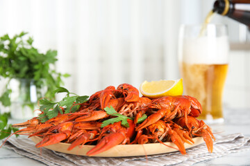 Delicious boiled crayfishes with parsley on white table