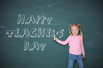 Cute little girl pointing on chalkboard with text Happy Teacher's Day
