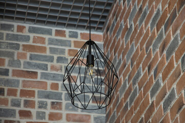 authentic black chandelier on a decorative brick background.  construction and renovation theme.  interior