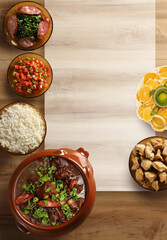 Feijoada, Brazilian food on wooden background. Top view with space for text