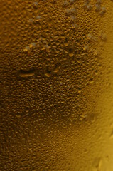 Wet glass of beer, golden color in the dark