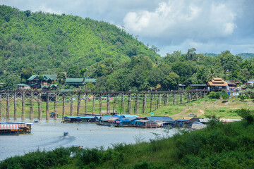 Fototapeta premium The old bridge made from wood at Sangkha buri in the evening time. Sangkhla-Buri, is in Kanchanaburi province of Thailand.