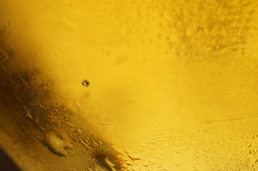 Wet glass of beer, golden color in the dark
