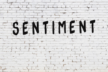 White wall with black paint inscription sentiment on it