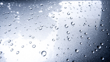 Gray automobile surface texture with rain droplets