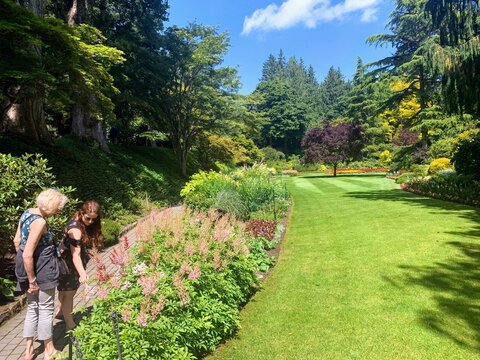 People walking around admiring the beautiful sights and smells of endless gardens at Butchart Gardens, in Brentwood Bay, Vancouver Island, Canada.