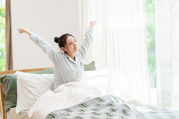ベッドから起きる女性