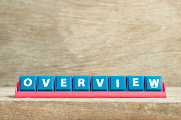 Tile letter on red rack in word overview on wood background
