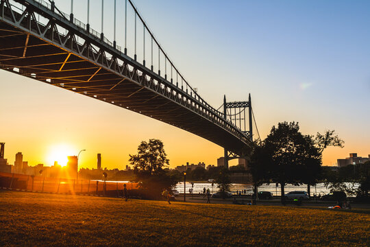 Bridge with sun setting in the evening  sky while children play in the grass