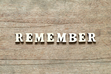 Alphabet letter block in word remember on wood background