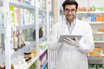 Business owner Middle eastern male pharmacist checking stock drugstore using digital tablet technology in modern pharmacy.