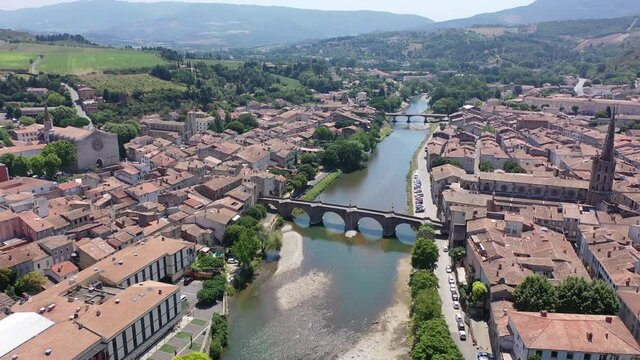 Scenic aerial view of French commune of Limoux on Aude River overlooking gothic spire of Church of Saint Martin in summer, Occitanie