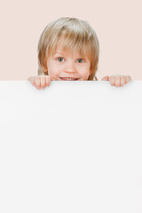 Cheerful positive child holding blank banner for text or advertisement