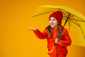happy emotional fun baby girl in autumn clothes laughing with a yellow umbrella