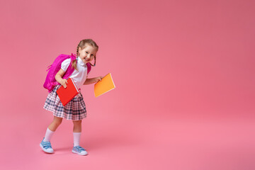 Back to school! Cute hardworking kid in uniform Jogging on pink background.