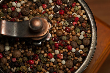 Photo mix of peppers in a hand-grinder close-up
