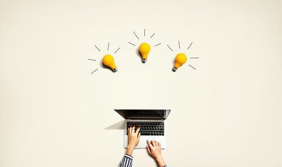 Person using a laptop computer with three light bulbs from above
