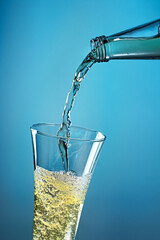 Fruit sparkling water is poured into a glass.