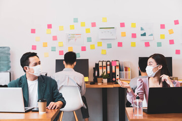 asian small business startup group wearing protective mask for covid19 protection corona flu prevent healty ideas concept office background.The work with new normal lifestyle in office.