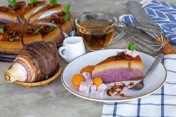 piece of taro chiffon cake topped with Thai taro custard and fried onion on white plate with tea, Concept of dessert and Thai dessert.