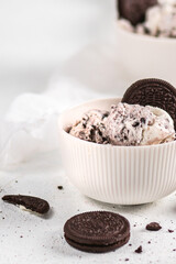 Vanilla ice cream with chocolate cookies on light background