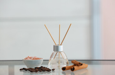 Obraz na płótnie Canvas Reed diffuser, cinnamon, sea salt and coffee beans on table