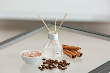 Reed diffuser, cinnamon, sea salt and coffee beans on table