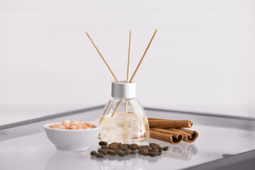 Reed diffuser, cinnamon, sea salt and coffee beans on table