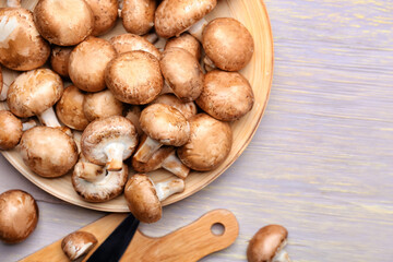 Plate with raw mushrooms on wooden background