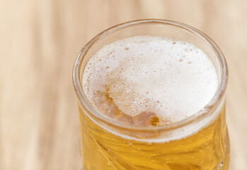 A glass of beer on a wooden background close up