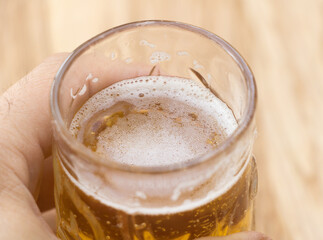 A glass of beer in a man's hand close up