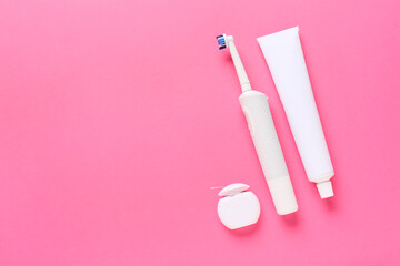 Electric tooth brush, paste and floss on color background