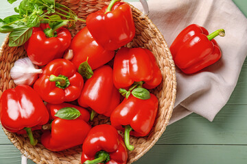 Wicker bowl with red bell pepper on wooden background