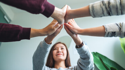 Low angle image of a group of young people putting their hands together