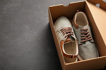 Pair of casual male shoes in box on grey background