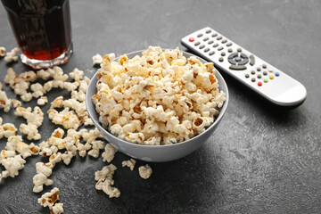 Popcorn, cola and TV remote control on grey background