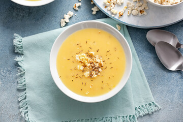 Bowl with tasty popcorn soup on table