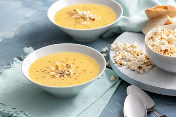 Bowls with tasty popcorn soup on table