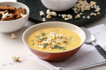 Bowl with tasty popcorn soup on table