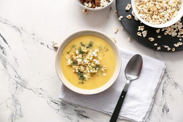 Bowl with tasty popcorn soup on table
