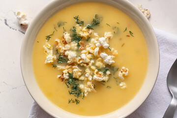 Bowl with tasty popcorn soup on table, closeup