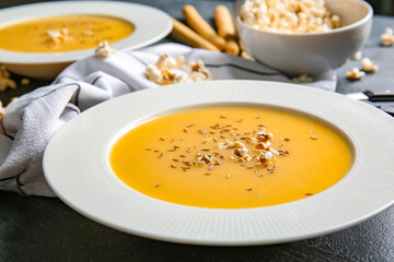 Bowl with tasty popcorn soup on dark background
