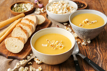 Bowls with tasty popcorn soup on table