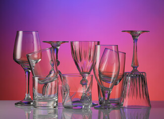 Empty glasses on color background